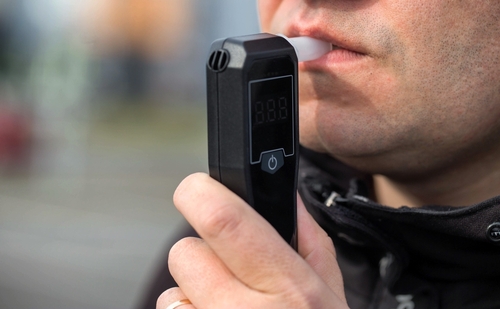 Man receiving a breathalyzer test at a DUI traffic stop