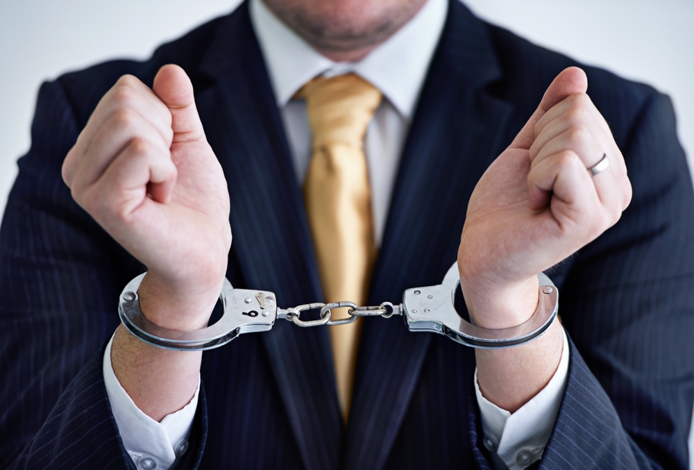 Stylized image of man in suit, tie, and handcuffs